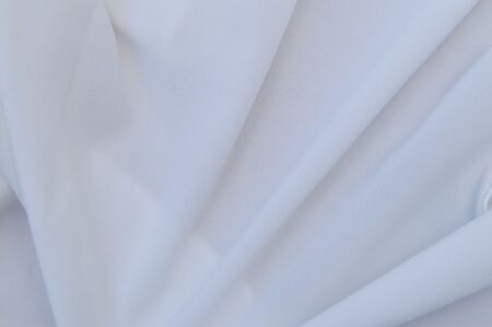 The Broderie Anglaise Cardigan Is Quietly Edging Out the Cotton Knit Close-up of broderie anglaise fabric with delicate eyelet embroidery detail