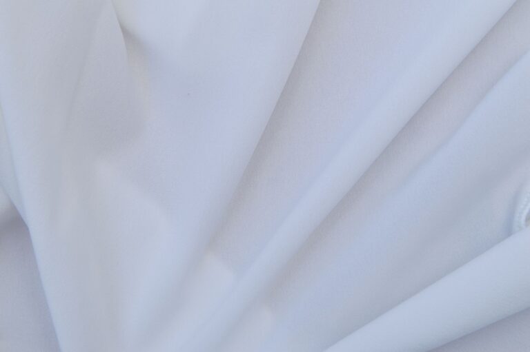 The Broderie Anglaise Cardigan Is Quietly Edging Out the Cotton Knit Close-up of broderie anglaise fabric with delicate eyelet embroidery detail