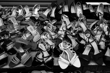 Close-up of gold metallic flat sandals on a light surface