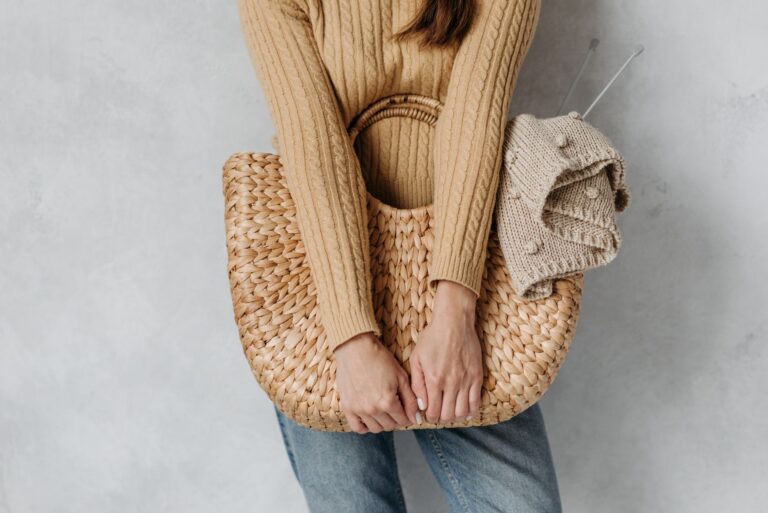 A structured raffia clutch bag with intricate weave detail on a neutral background