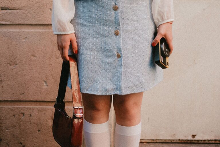 The Tweed Micro-Bag Is Quietly Edging Out the Leather Belt Bag A small structured tweed micro-bag with a gold chain strap against a neutral background