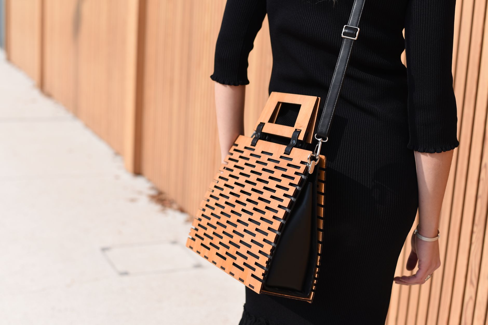 Close-up of woven ribbon trim detail on a leather handbag