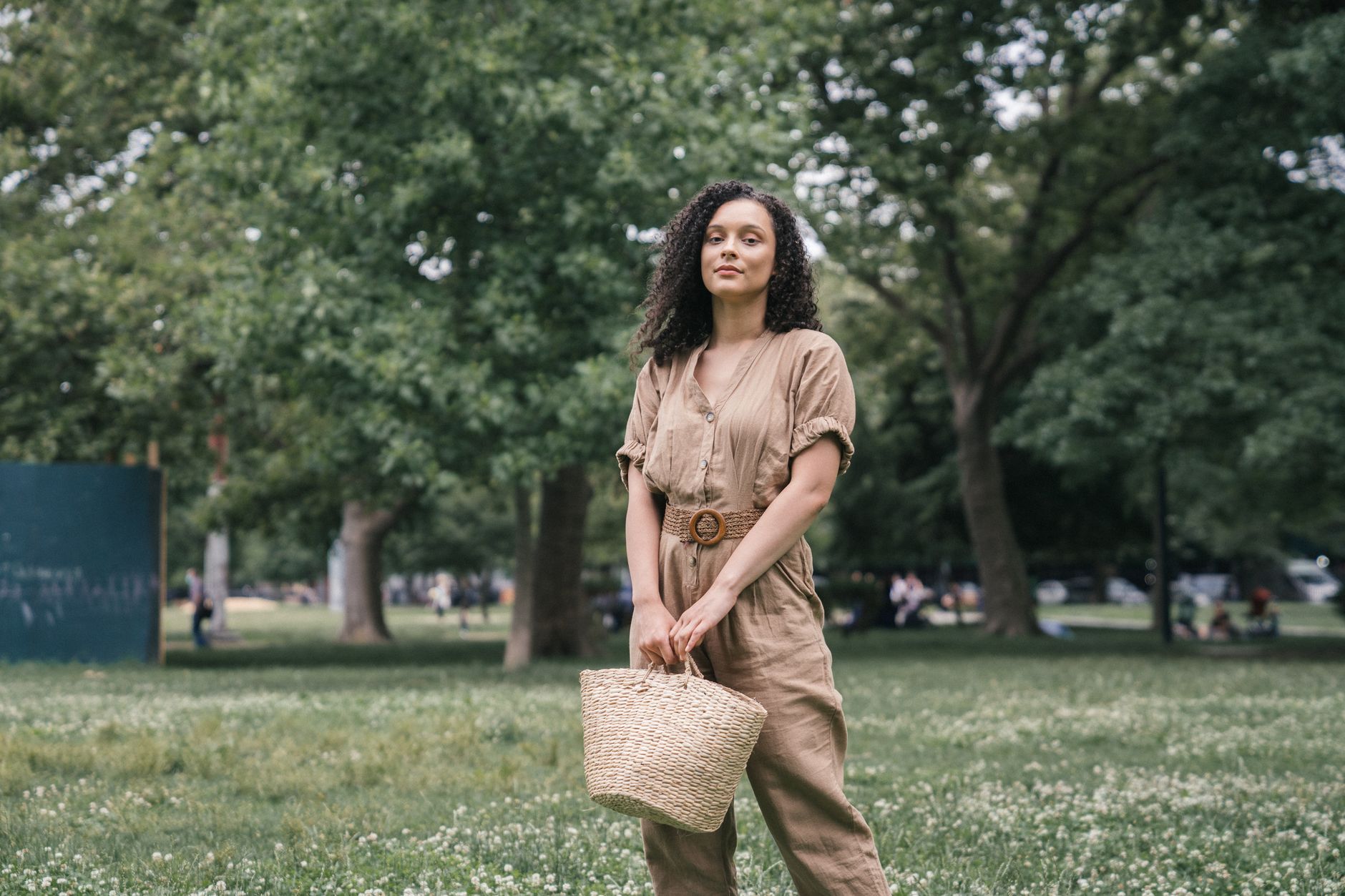 A natural straw woven tote bag photographed outdoors in natural light