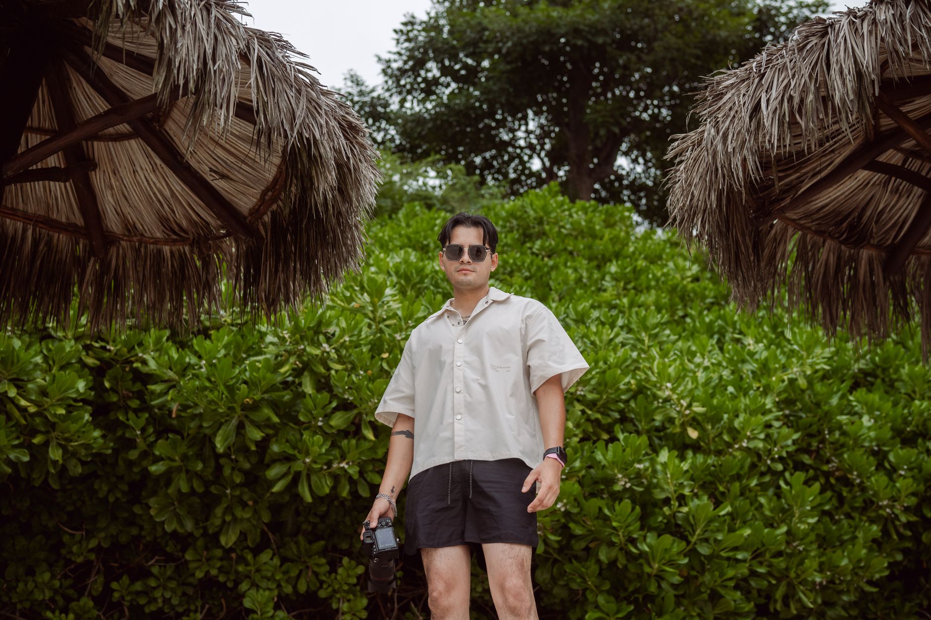 Elegant beachside outfit styled with minimal jewelry and linen trousers