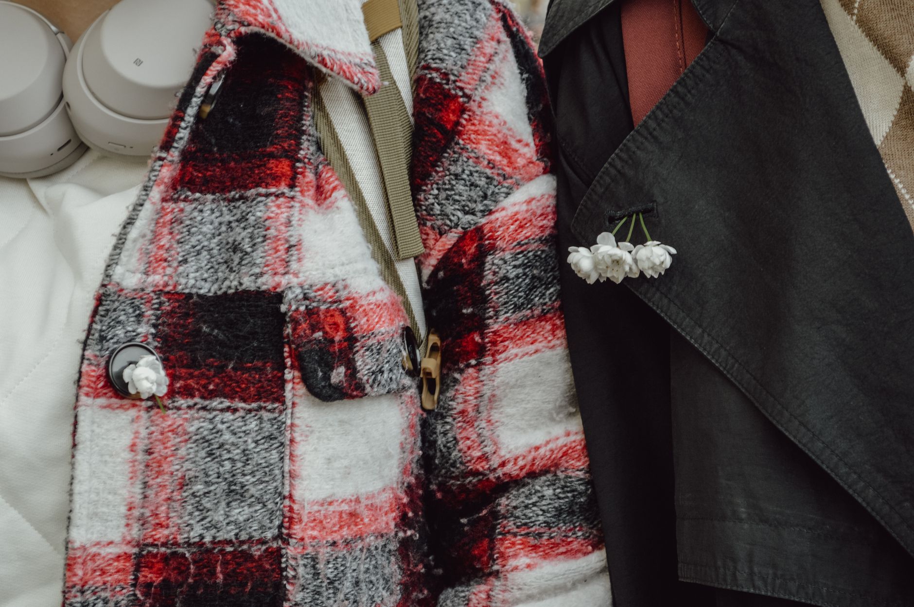 Close-up of textured outerwear fabric showing embroidery and eyelet detailing