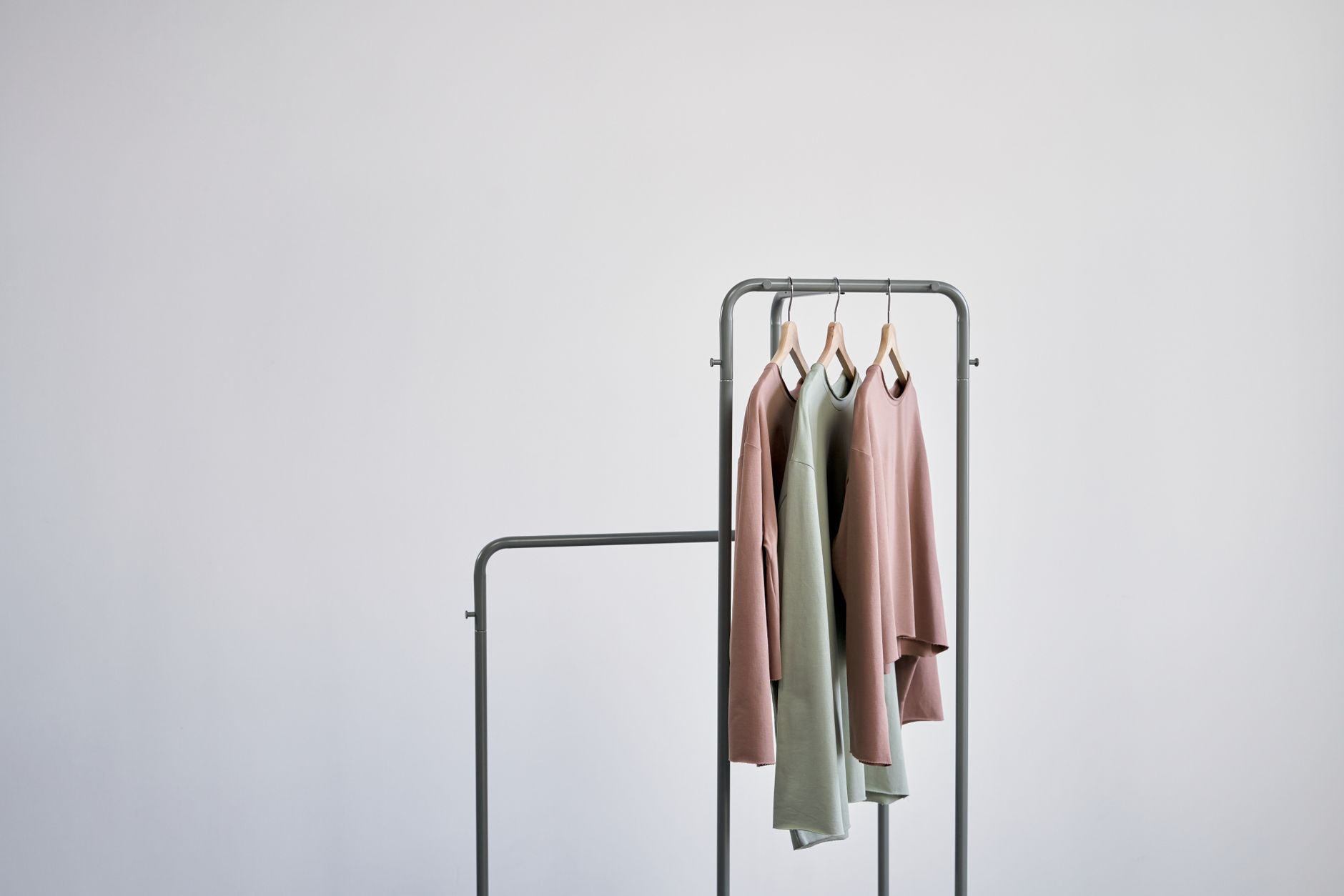 A clean, organized wardrobe featuring neutral-toned clothing and tailored pieces