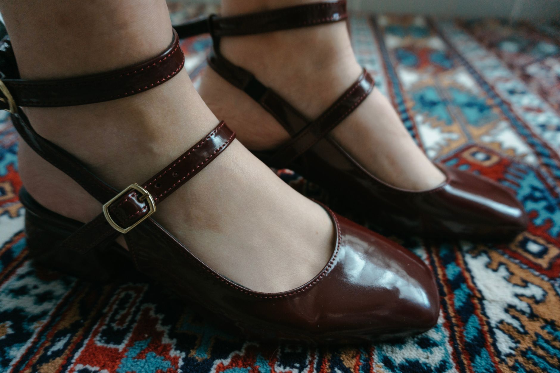 Detail shot of a suede kitten heel pump against a minimal background